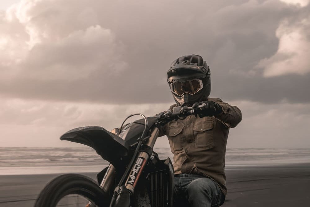 man doing a wheelie on a motorcycle in the sand