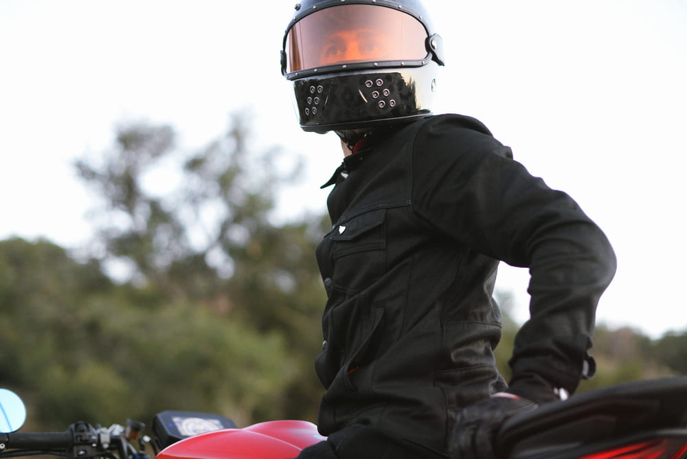 man sitting on motorbike wearing a helmet and jacket with motorcycle armour
